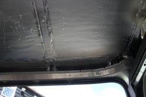 Lining Roof above door during a van conversion. Photograph shows insulation board and vapour barrier.