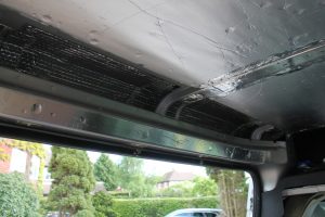 Lining the Roof above sliding door during a van conversion. Photograph shows insulation and vapour barrier installed.